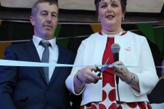 Noreen Mc Garvey cuts the ribbon to officially open the Burtonport festival on Saturday night in the company of committee member Paddy Bonner.